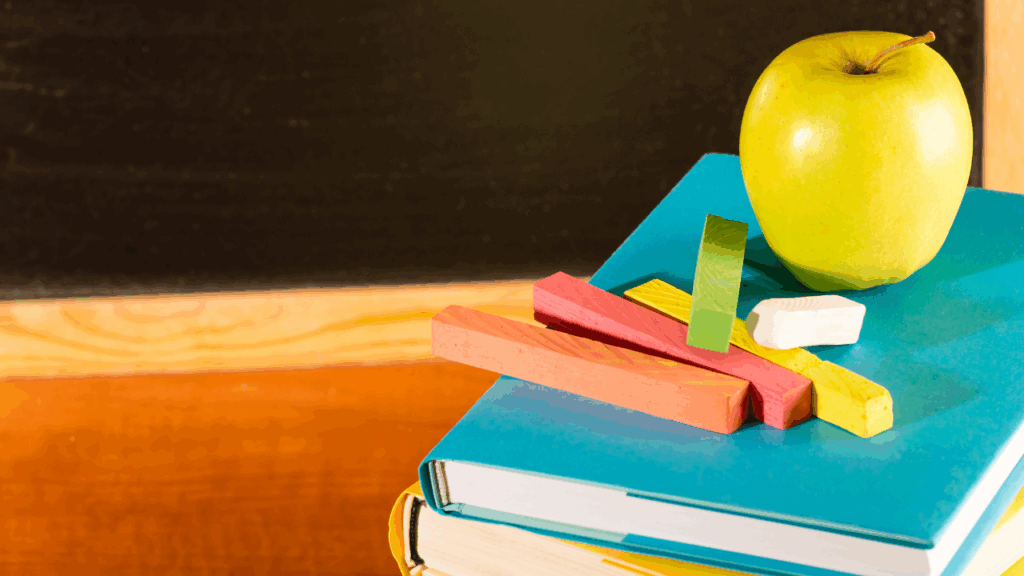A book and a green apple resting on table