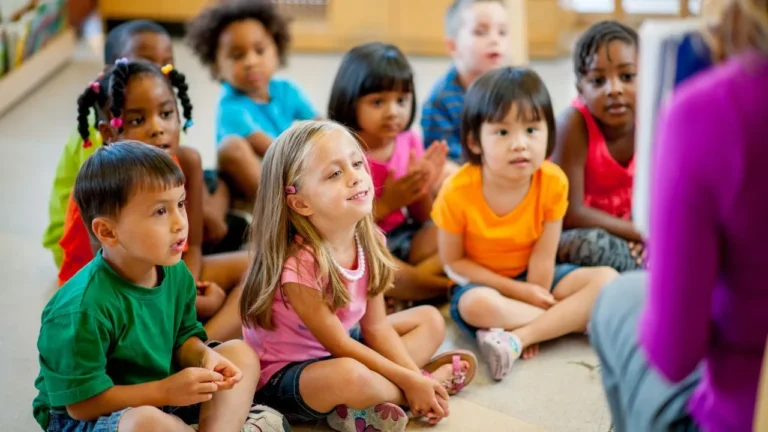 Students seated on the floor listening to the teacher