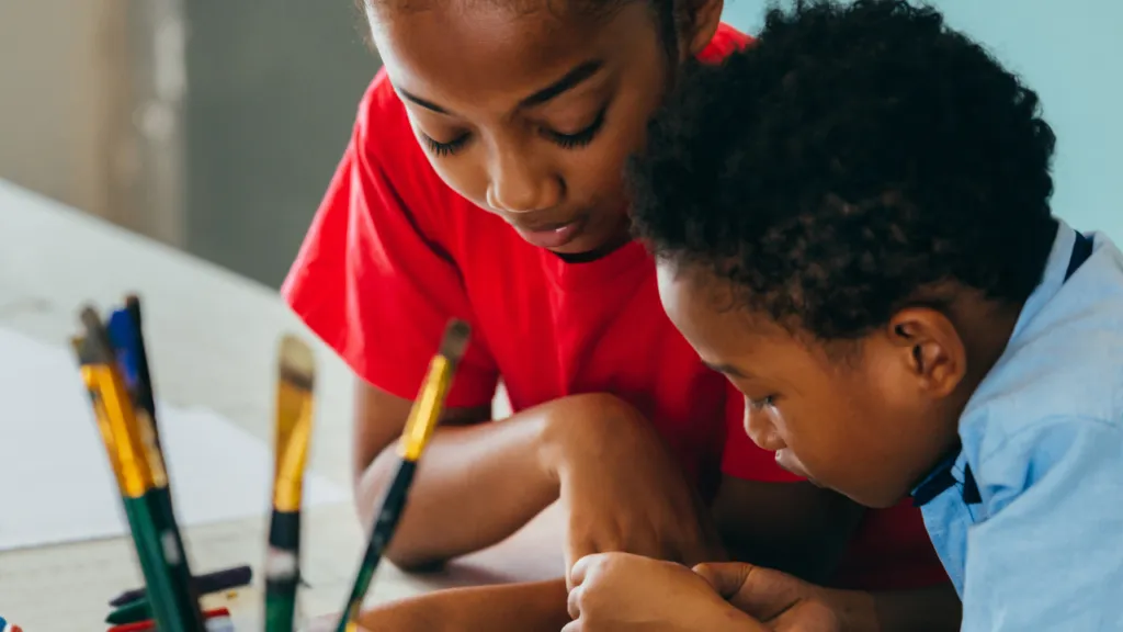 Two young kids working on a assignment together.