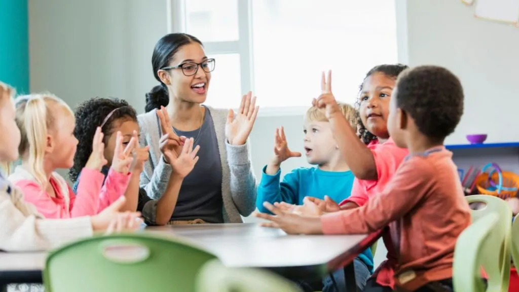 Teacher holding up two fingers while students do the same