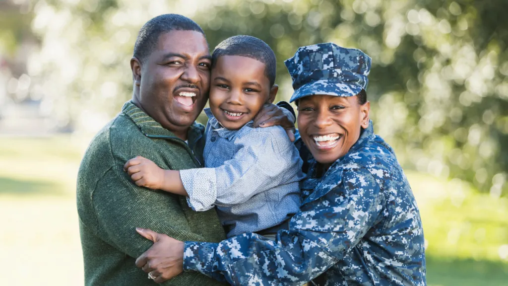 Military mother and father holding their toddler together for a family portrait