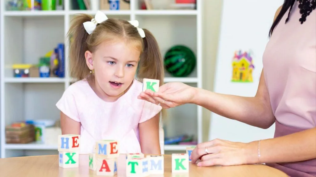 A girl reciting the letters of the alphabet