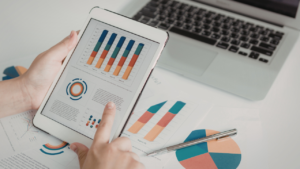 Person looks at an iPad displaying graphs and chart